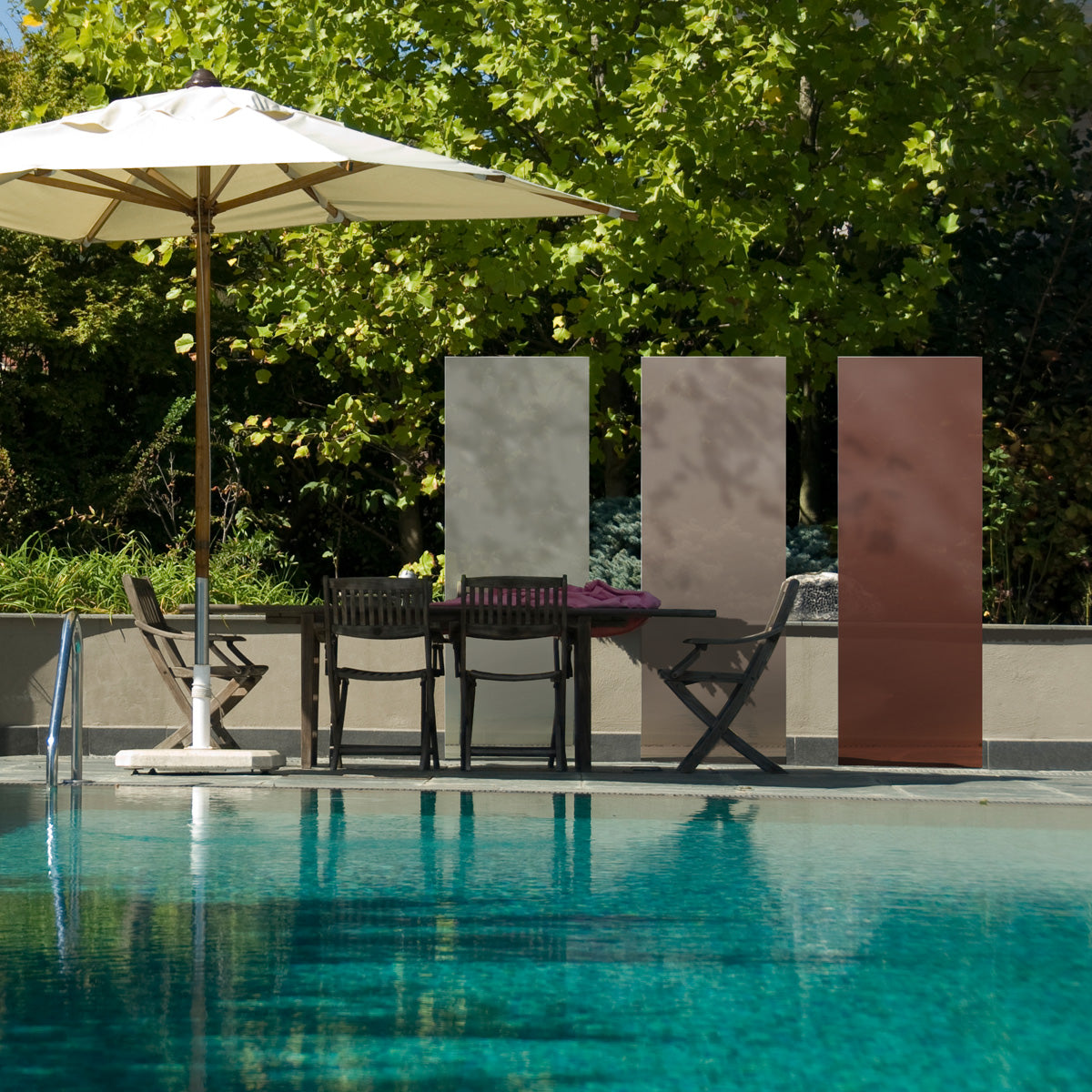 Drei beige-braune KNUMOX Glasdesign Elemente stehen an einem Pool neben einem Sonnenschirm.