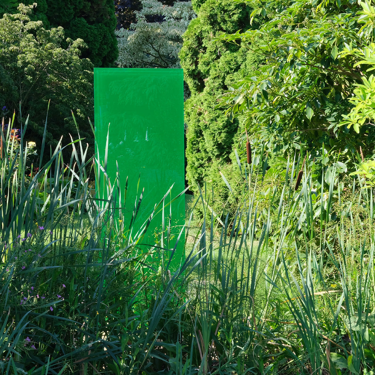 Das KNUMOX Element Apple mit grüner Farbe inmitten von üppiger grüner Bepflanzung.