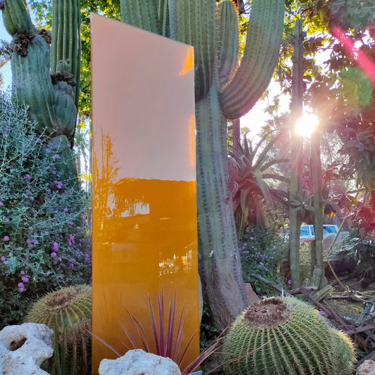 Das Glaselement mit orangener Farbe steht zwischen Kakteen im Aussenbereich von "Jardins de Tramuntana" in Mallorca.
