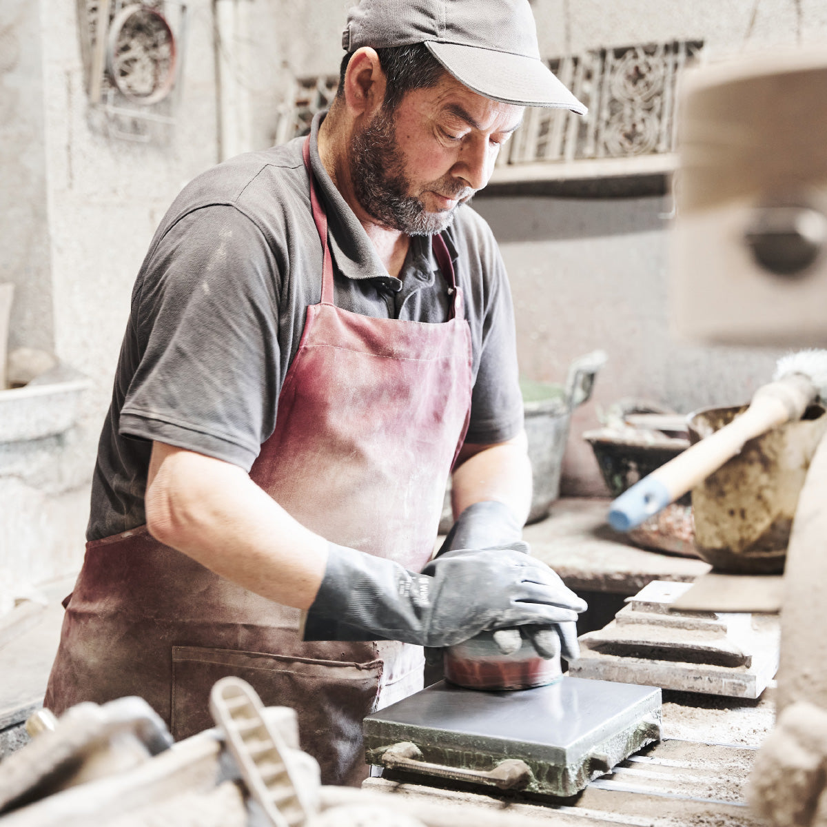 Mitarbeiter der  Fließenmanufaktur Huguet in Mallorca bei der Arbeit an einer handgefertigten Fließe.