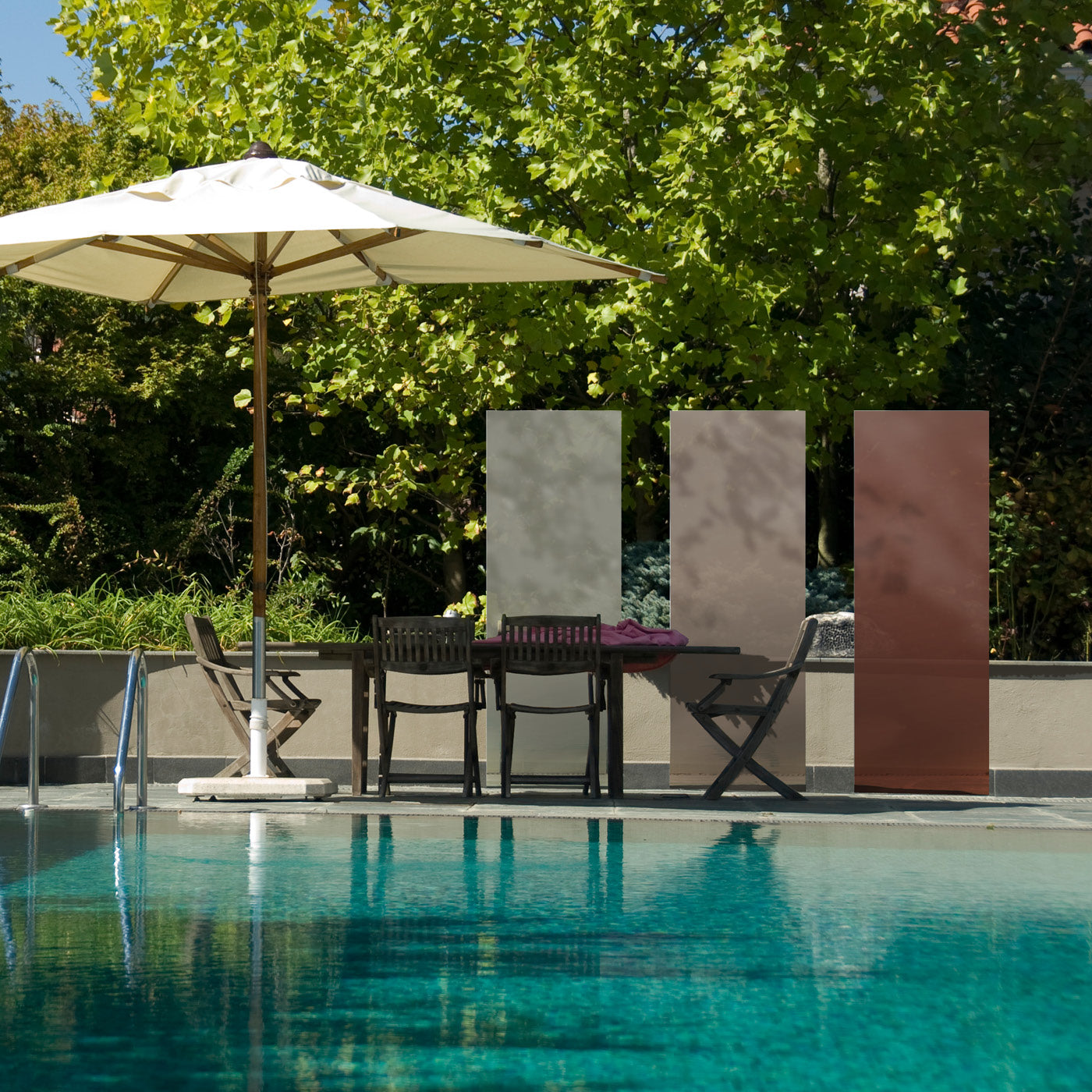 Drei beige-braune KNUMOX Glasdesign Elemente stehen an einem Pool neben einem Sonnenschirm.